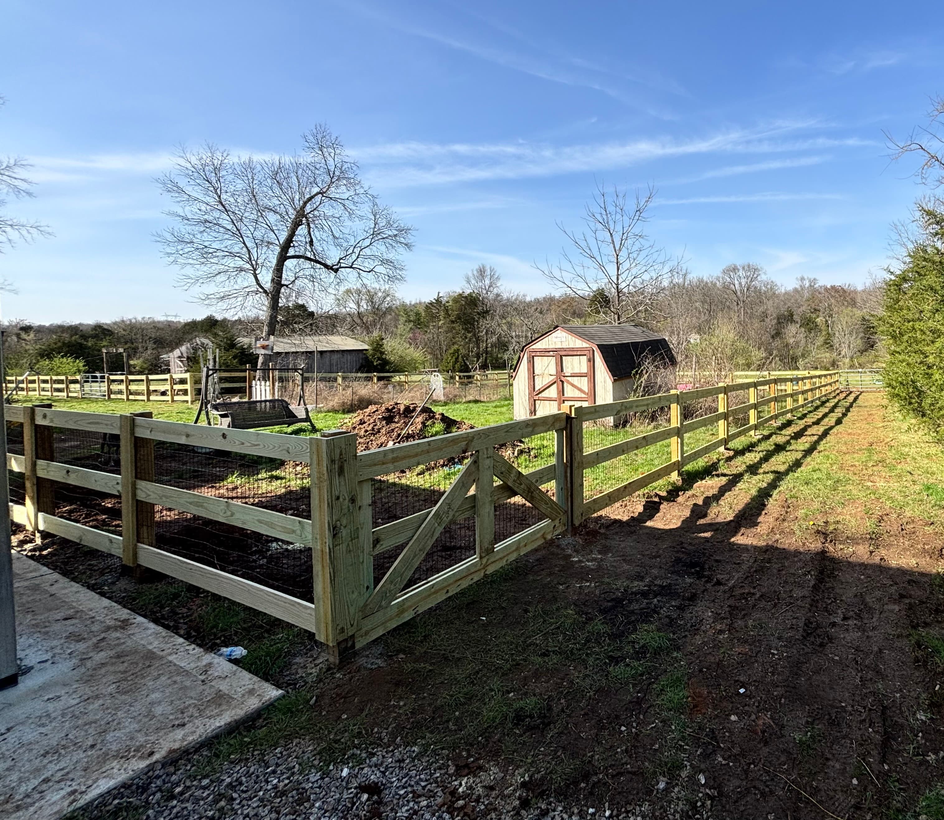 Three-rail board fence with wire and gate for livestock, Middle Tennessee farm