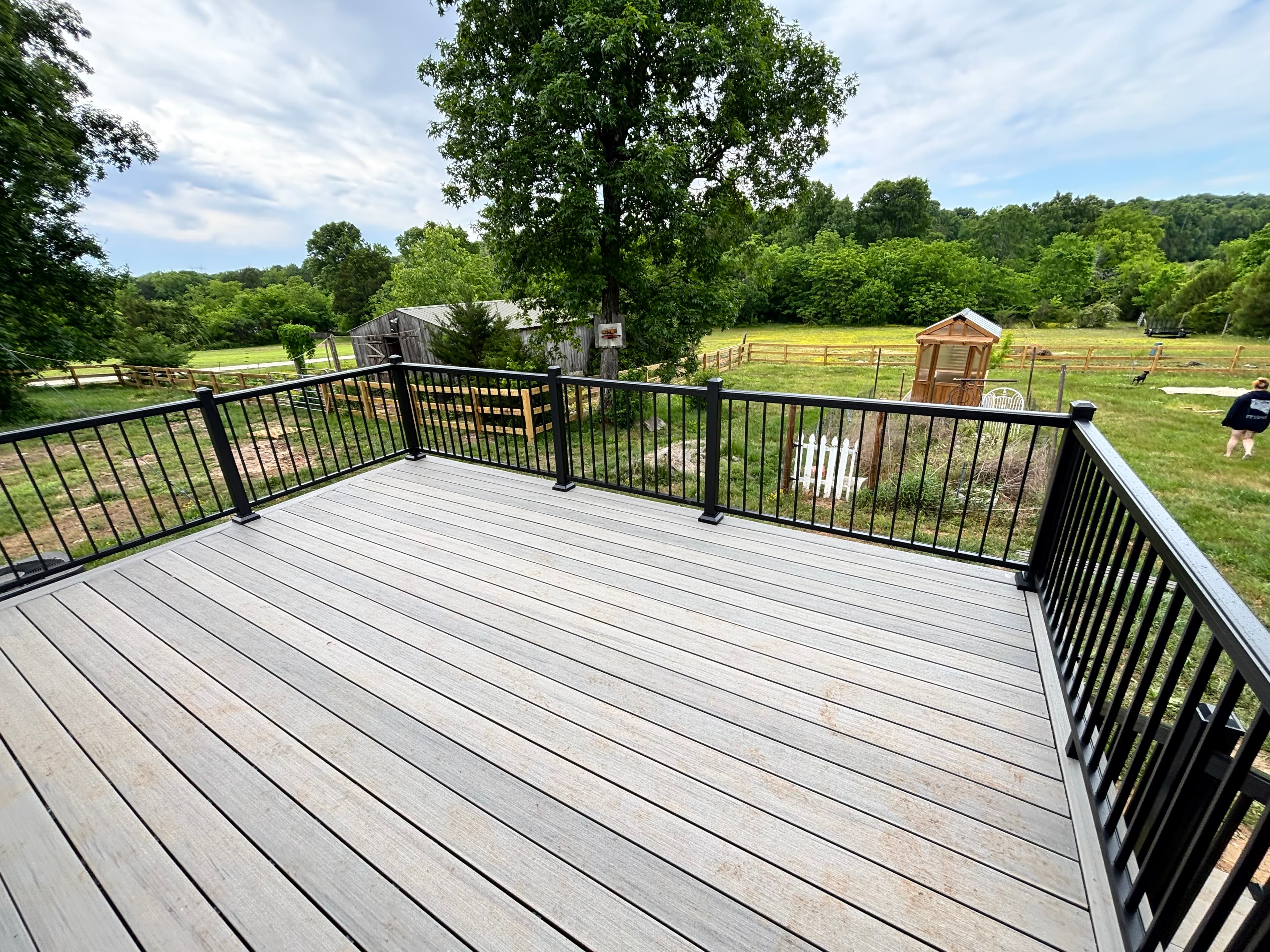 Composite deck with black aluminum railing overlooking open field, Middle Tennessee