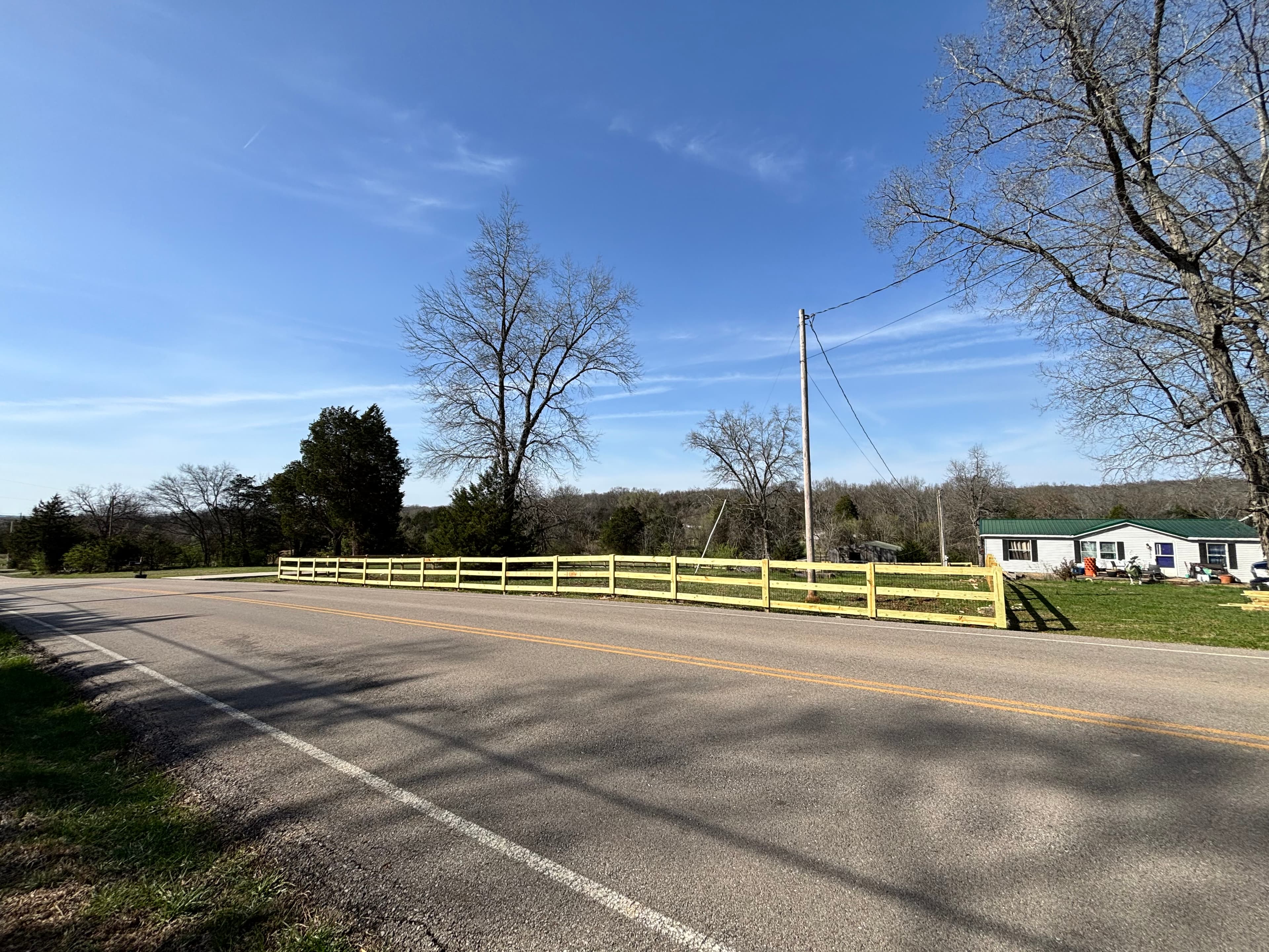 Painted three-rail farm fence along rural roadside in Middle Tennessee