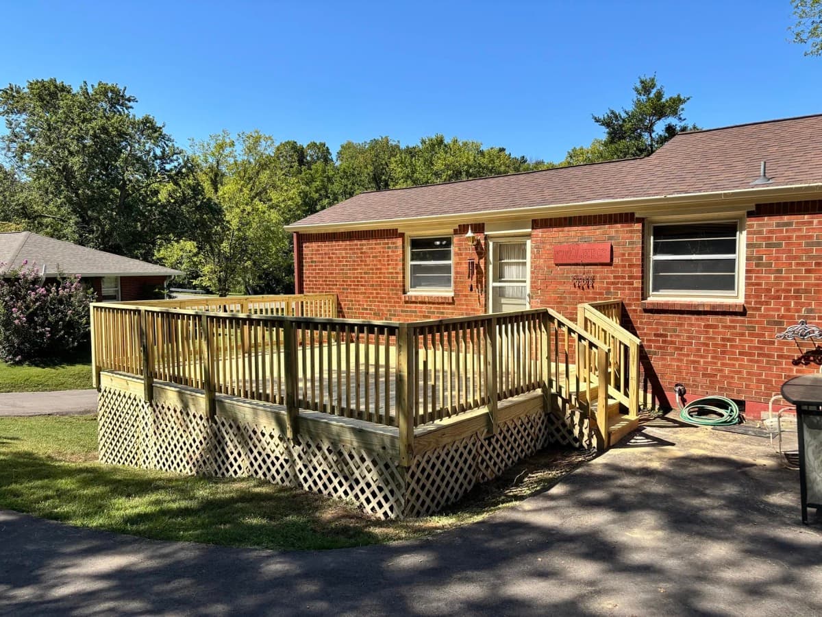 Pressure-treated wood deck with lattice skirting on brick ranch home in Middle Tennessee